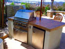 Small arc BBQ with tile top, stucco sides, a built in refridgerator, and serving shelf.  Click on image for a larger picture.