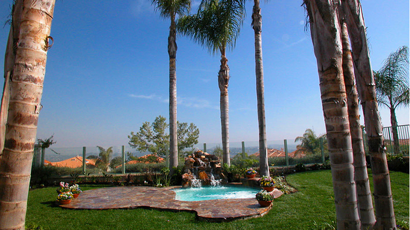 The 2003 NSPI Bronze Award winner, this intimate creation was inspired by the natural majesty of a palm grove in the corner of a Laguna Niguel property. Great columns of trees frame a waterfall of real stone, cascading into an organically shaped spa surrounded by Three Rivers stone hardscape.