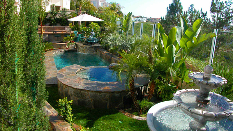 Here, a simple, sloping Laguna Niguel yard is transformed into a terraced paradise with an Asian influence. A blue Pebblecoat plaster creates two jewels in a sculptured setting of Red Mountain stone. Between them, a spillway fountain creates hypnotic sound and motion.