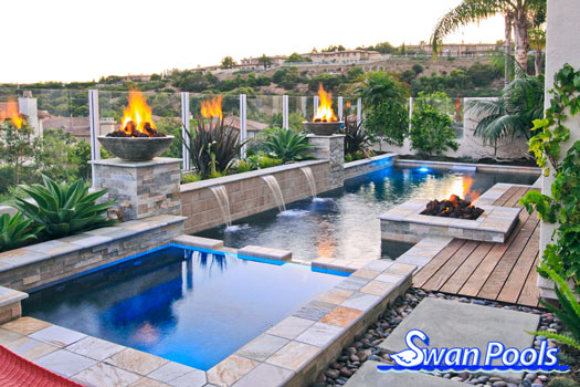 Geometric swimming pool and spa installed with fire bowls and a fire pit entertainment area in Newport Beach, California.