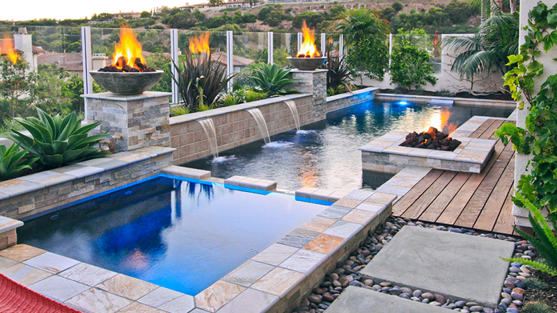 Geometric swimming pool and spa installed with fire bowls and a fire pit entertainment area in Newport Beach, California.
