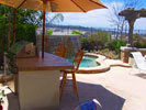 Small arc BBQ with tile top, stucco sides, a built in refridgerator, and serving shelf.  Click on image for a larger picture.