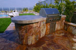 Small arc BBQ with tile top, stone sides, and a circular table top.  Click on image for a larger picture.