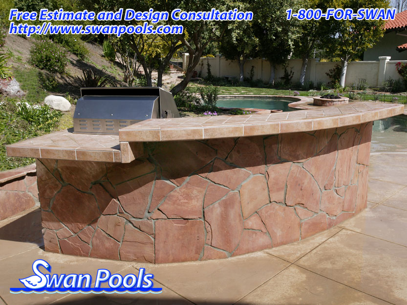 Small arc BBQ with tile top, raised serving shelf, and stone sides.