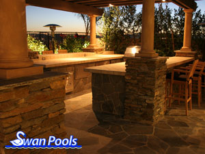 Custom U-shape, outdoor kitchen barbeque with tile top, ledger stone veneer, and custom overhead patio cover.  Click on image for a larger picture.
