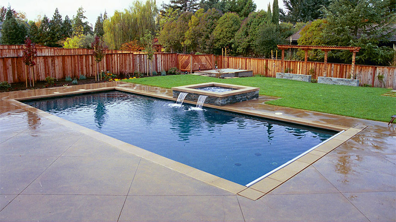 An ordinary backyard becomes a meditative sanctuary, with clean, pure lines and simple shapes. The surfaces are natural stone veneer and scoured concrete, with a simple gray plaster in the pool and spa. The eye is drawn to two shallow spillways - the only movement in a serene landscape.