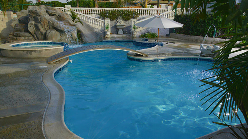 Climb to the top of the grotto, beside the waterfall, and slide down to the pool.  Swim up to the bar. Stroll across the bridge and sweep your legs into the spa. Slip back into the pool, under the spray of a sculpted dolphin fountain. In this Villa Park property, every day seems like a vacation.